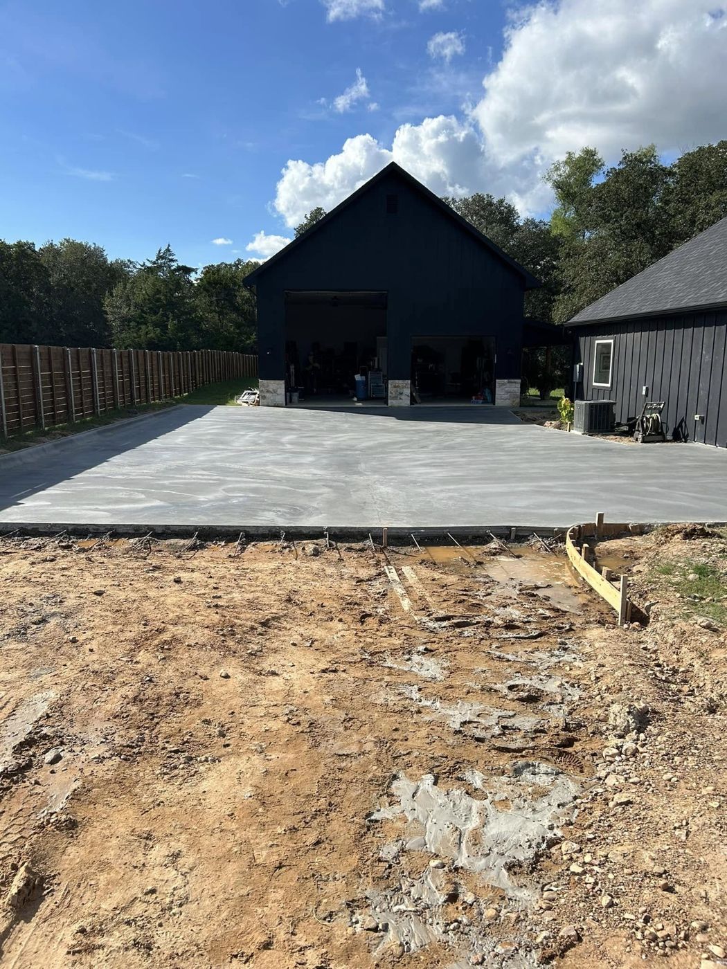 Freshly Finished Slab: The full-width concrete apron in front of the shop, just finished.