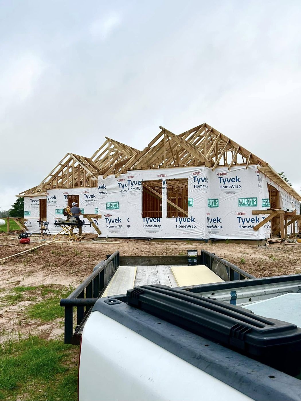 Trusses & House Wrap: Roof trusses set and the house wrapped and ready to dry in.