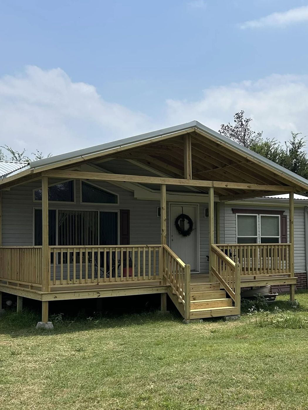 Covered Front Porch: New covered porch with railings and wide steps.