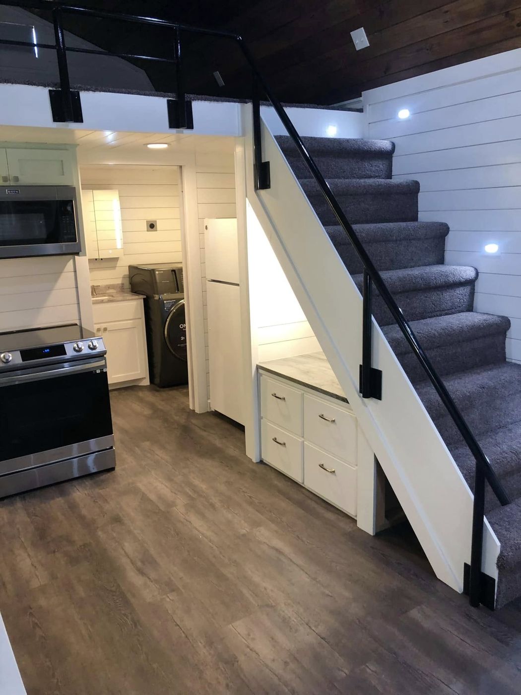 Tiny House Interior: Full kitchen, laundry, storage under the stairs and a sleeping loft.