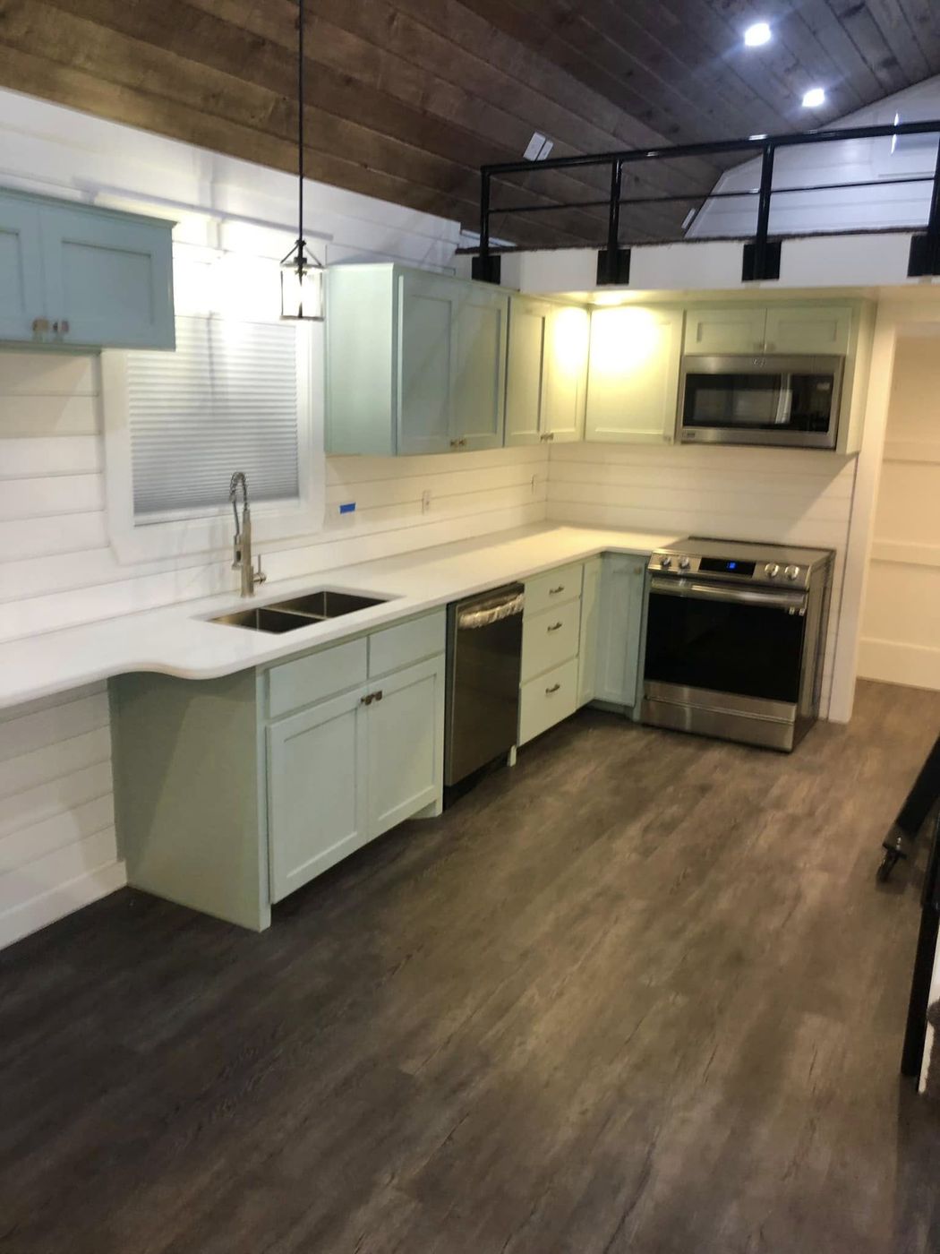Tiny House Kitchen: Sage shaker cabinets, quartz counters, stainless appliances and a wood plank ceiling.