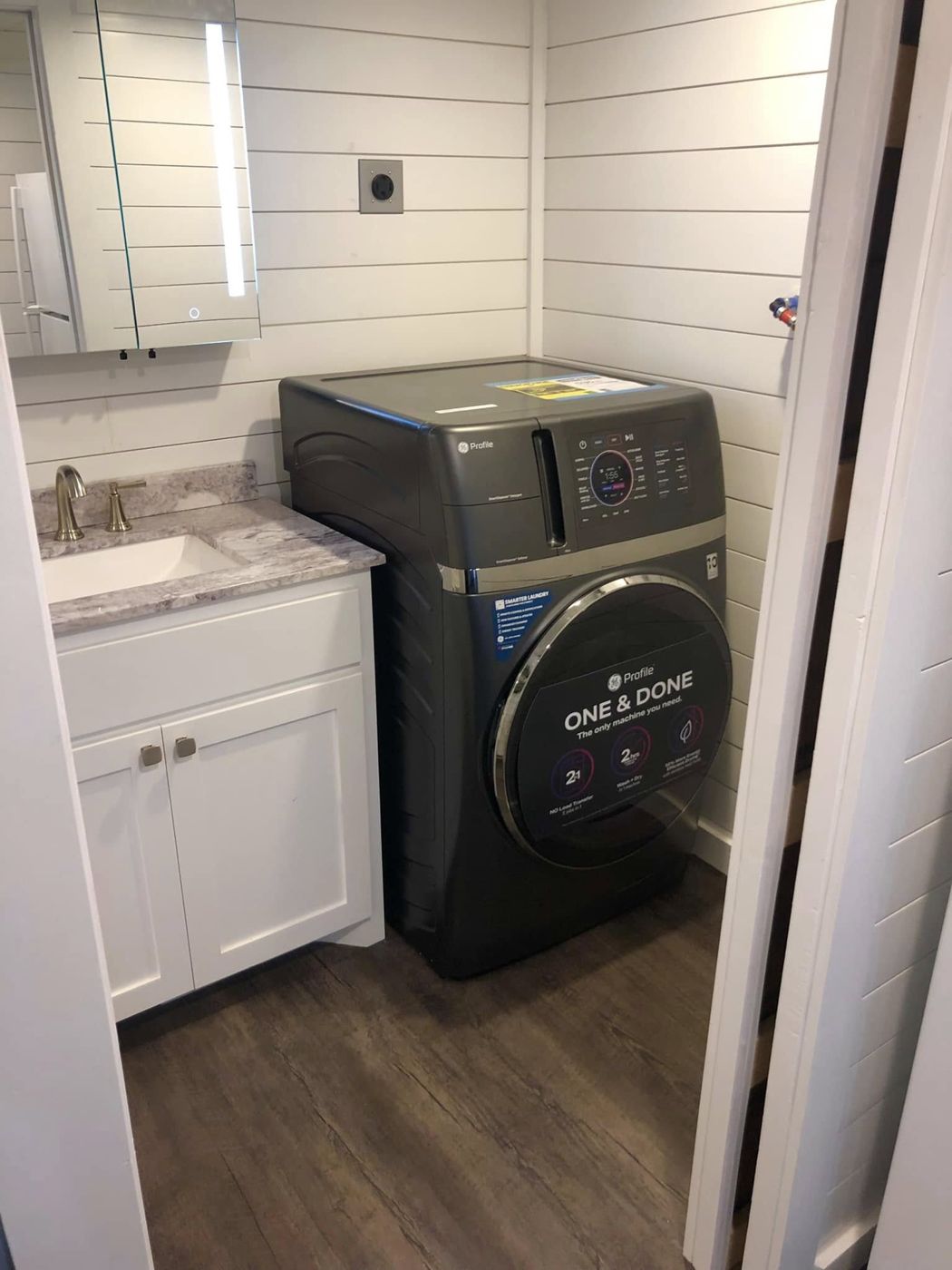 Laundry and Vanity: Washer-dryer combo beside a granite-topped vanity.