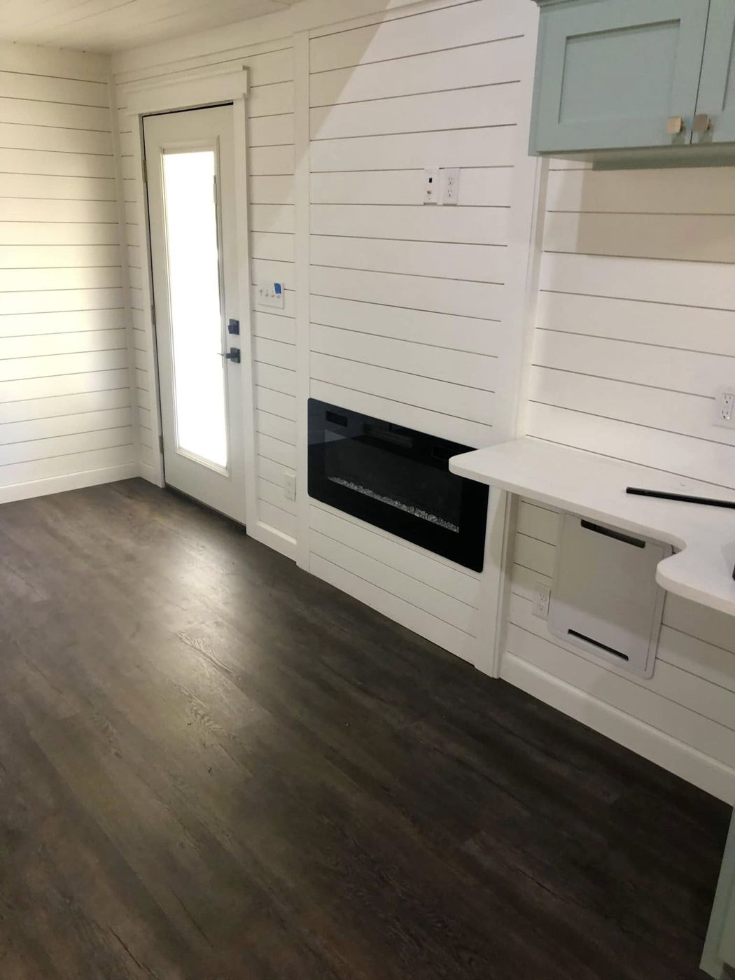 Living Area: Shiplap walls, a built-in electric fireplace and a wraparound counter.