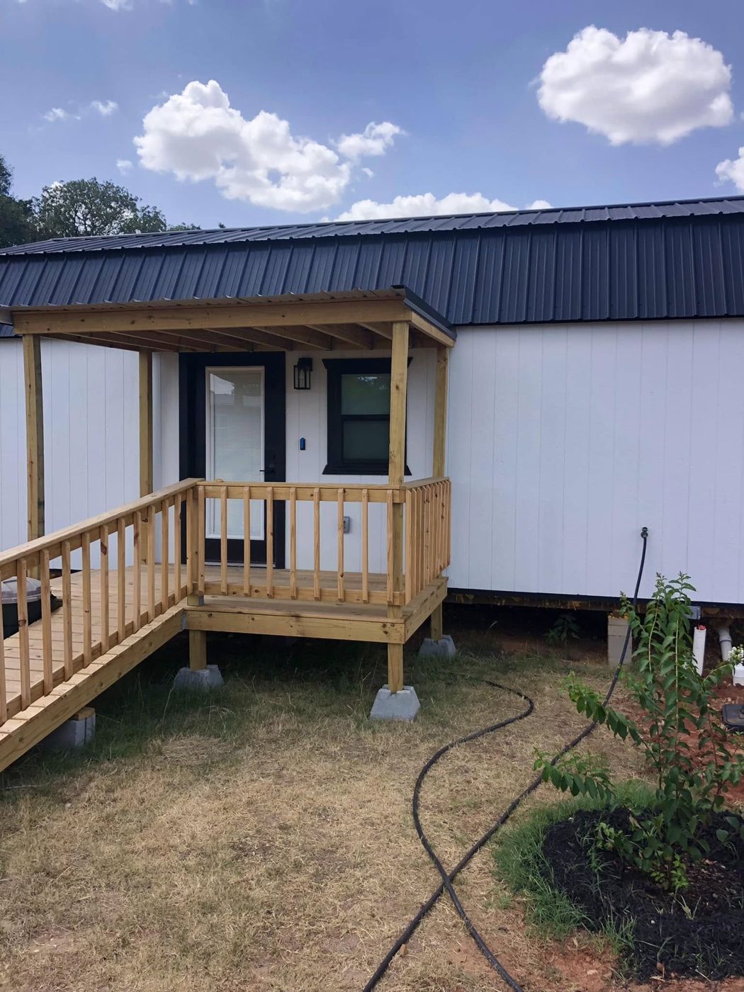Shed to Tiny House: A storage shed turned into a tiny home, with a covered porch and wheelchair ramp at the front door.